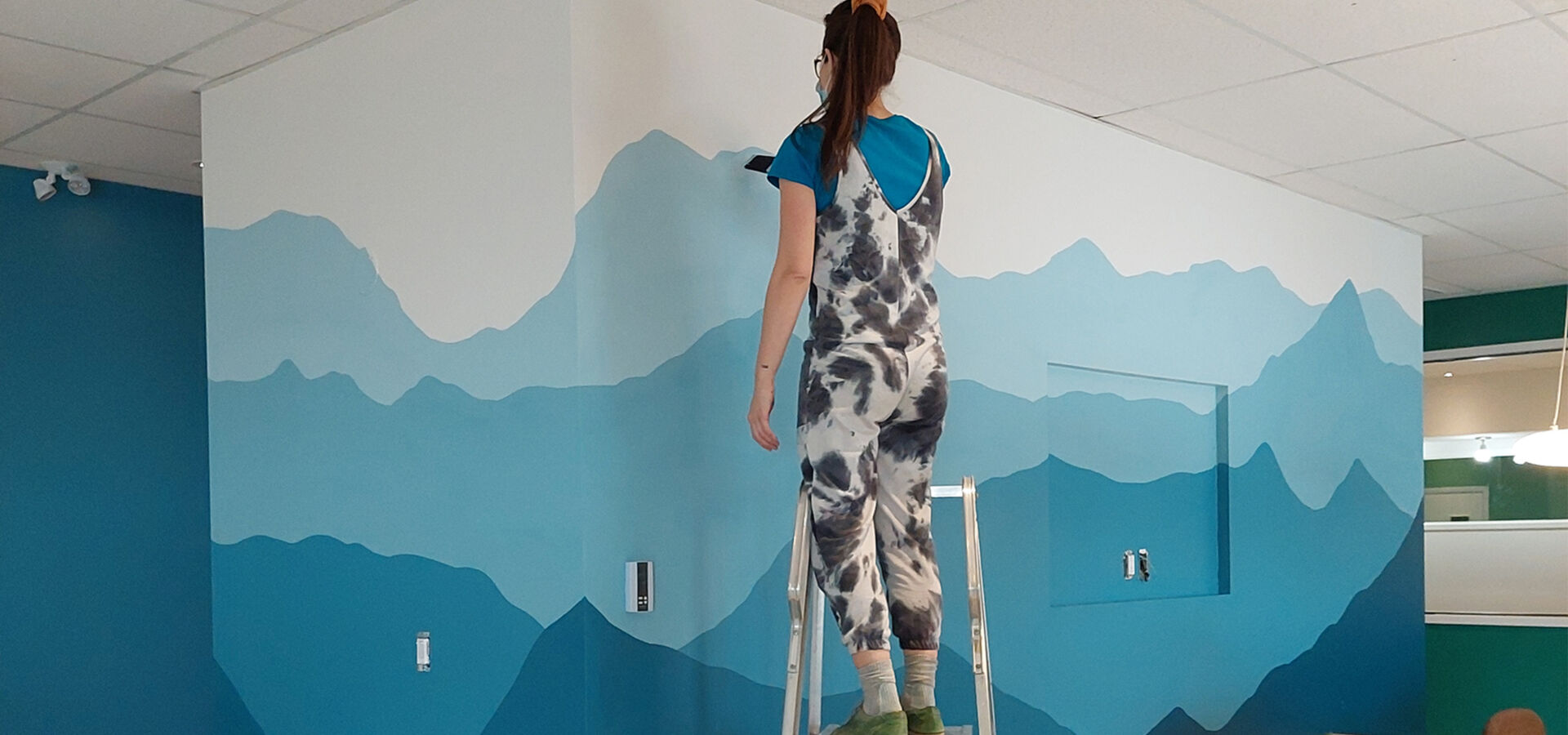 Murale d'accueil en cours de réalisation — peinture de montagnes bleutées, Centre communautaire de Bromont