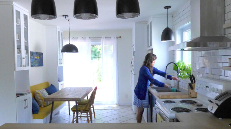 Vue avant rénovation de la cuisine avec armoires blanches et comptoir de bois, projet Audrée à Bromont