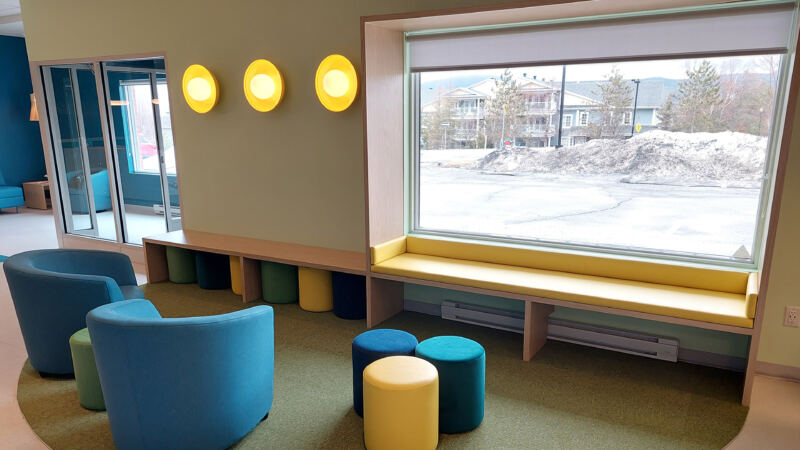 Vue d'ensemble de la salle multifonctionnelle avec murale et espaces de travail, Centre communautaire de Bromont
