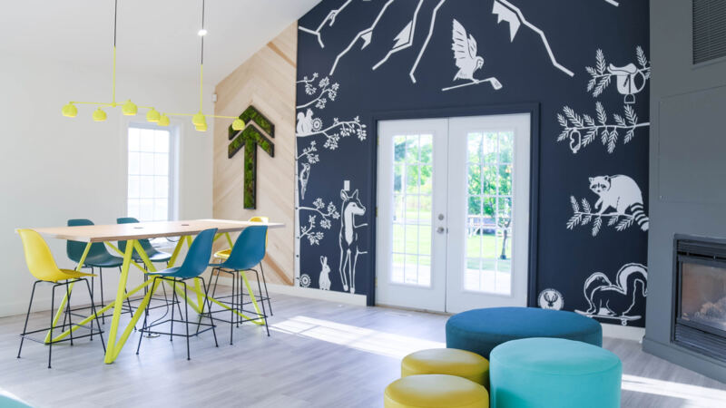 Mur de briques foncé avec illustrations d'animaux de la faune québécoise, Bureau touristique de Bromont